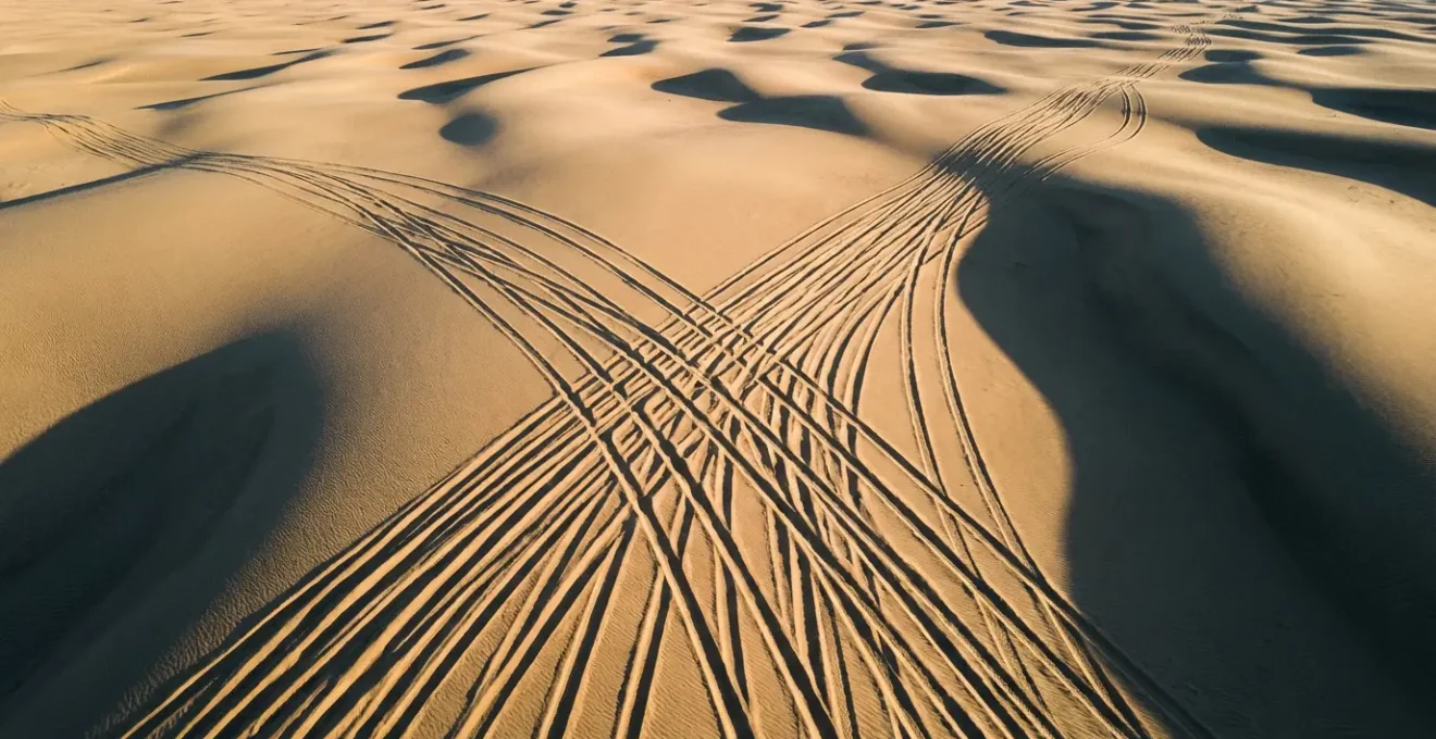 Traces de pneus divergentes dans le sable créant confusion pour la navigation